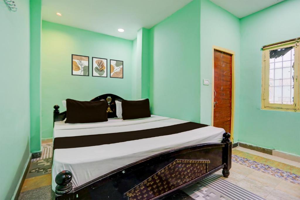 a bed in a room with blue walls at Hotel O Surya Lodge in Guntūr