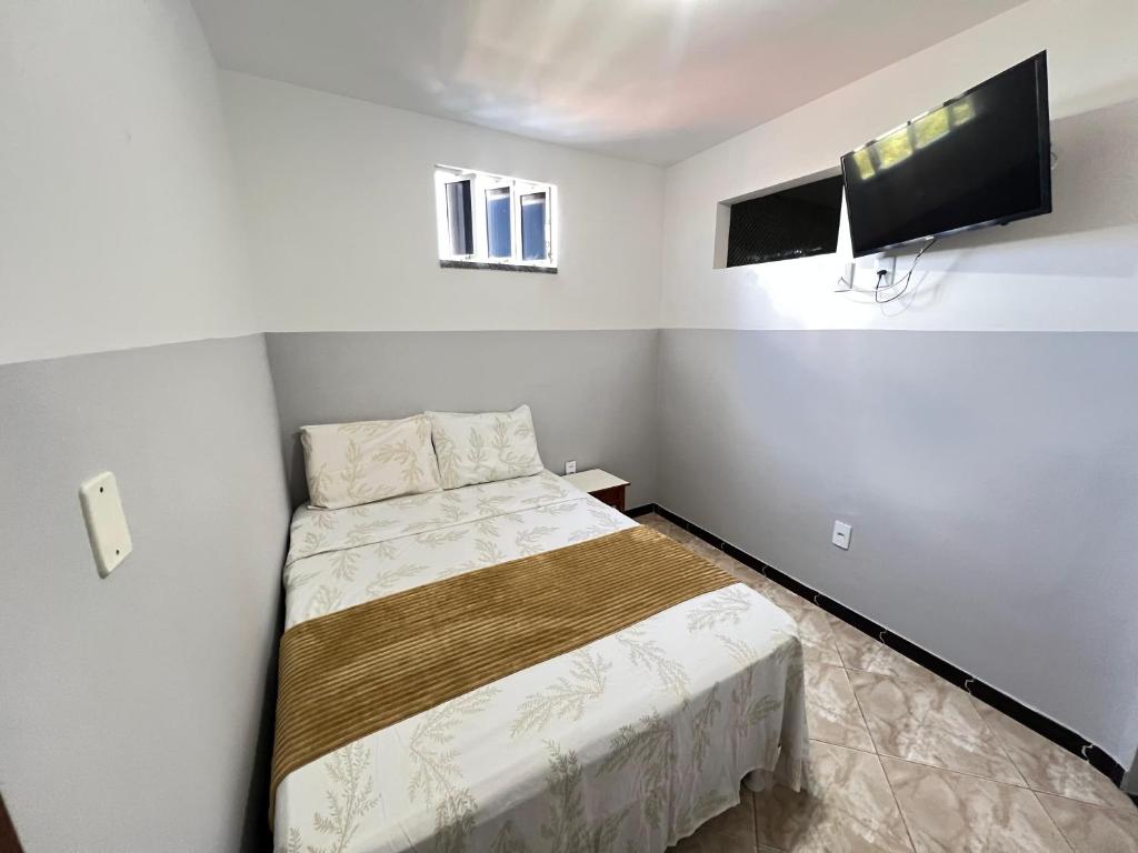une petite chambre avec un lit et une télévision à écran plat dans l'établissement Apartamento a 1 km da Orla de Atalaia 2º andar, à Aracaju