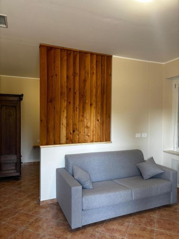 a living room with a couch and wooden wall at Elegante bilocale a due passi dal centro in Saluggia