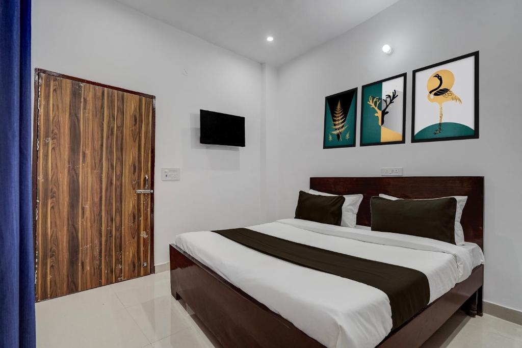 une chambre avec un grand lit et une porte en bois dans l'établissement Hotel O SGT University Road Formerly Budhera, à Dhankot