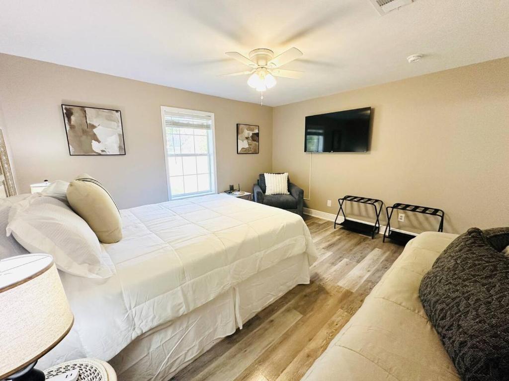 a bedroom with a large white bed and a couch at Eastgate 9A Beautiful Townhouse in Hammond