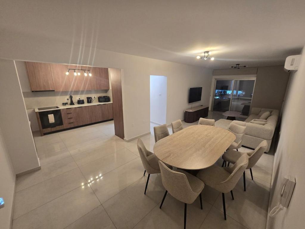 a dining room and living room with a table and chairs at Maestro Family - Apartment in Larnaka