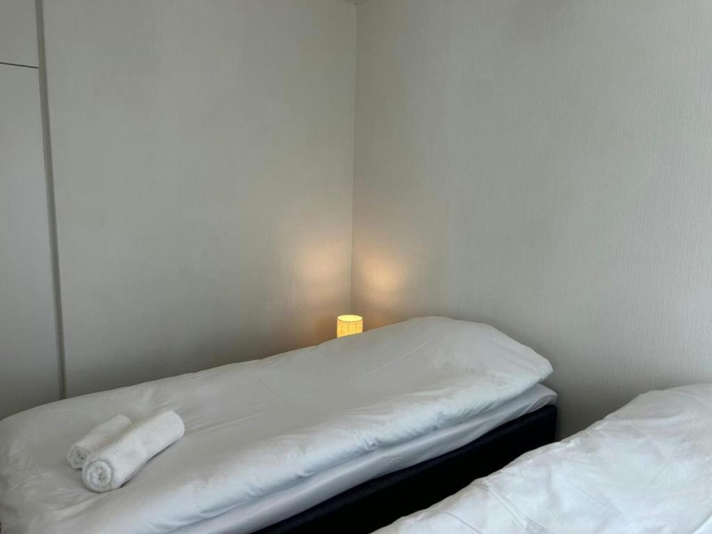 two white beds in a room with a lamp at Convenient Apartment for 4 with Sauna in Törnävä