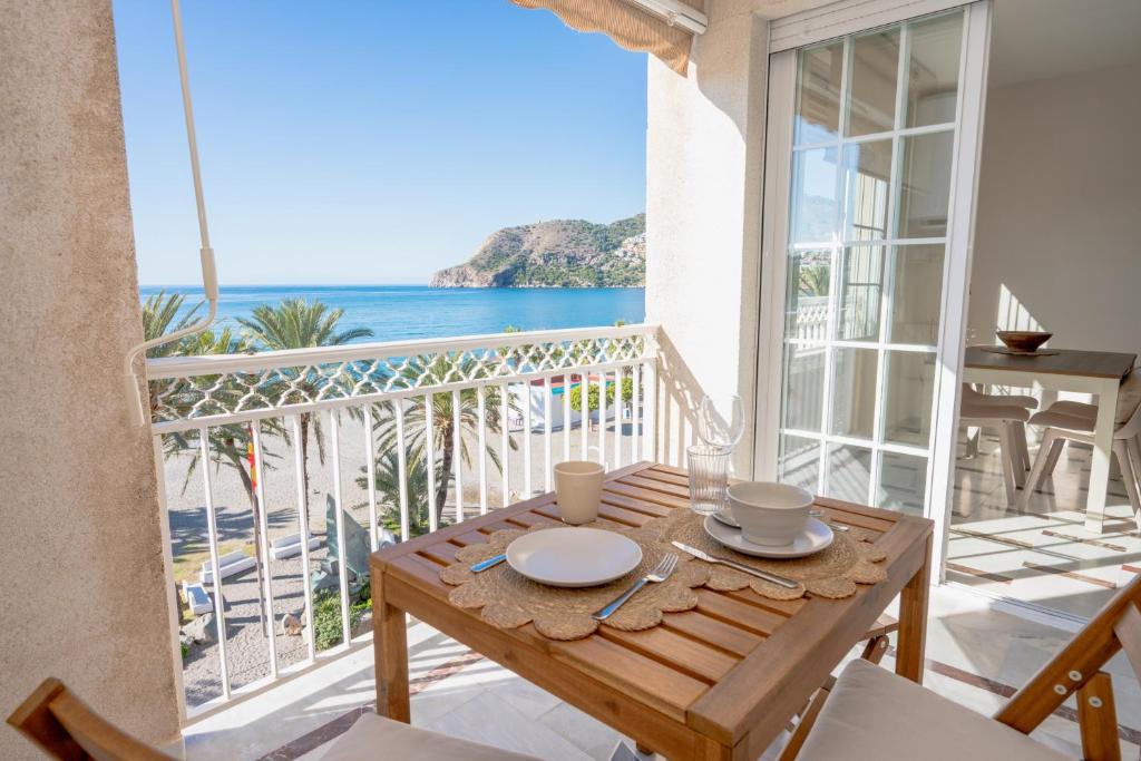 a dining table with a view of the ocean at Apartamento LH Beach frente al mar in La Herradura