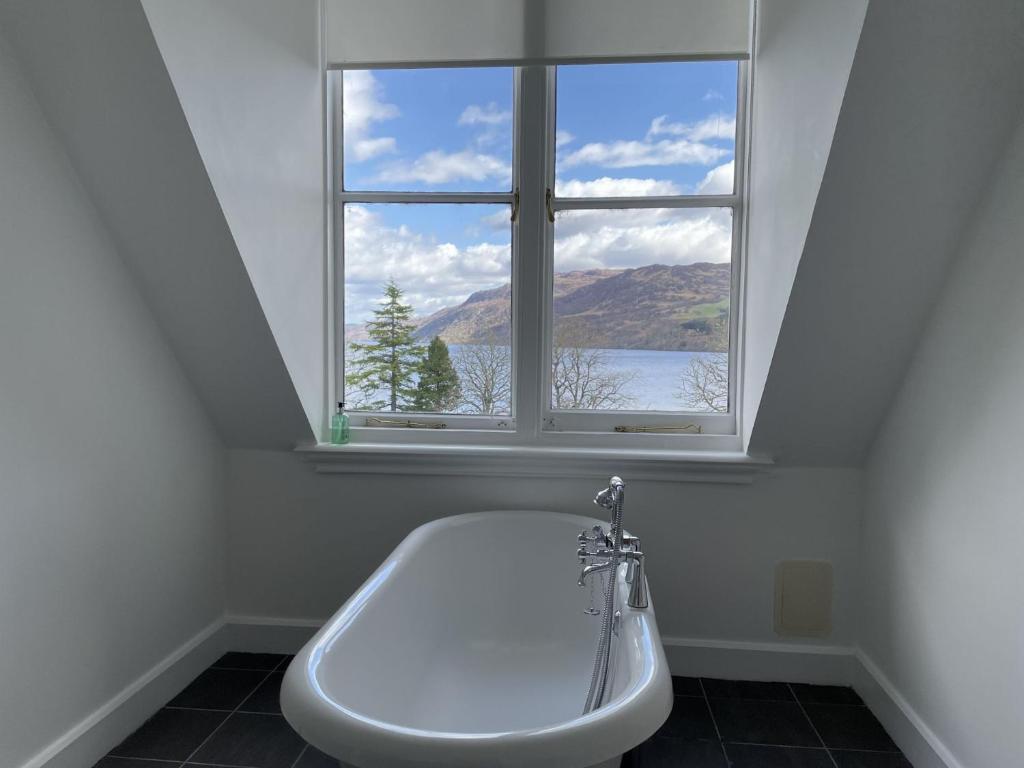 een badkuip in een badkamer met een raam bij Monastery 17 in Fort Augustus