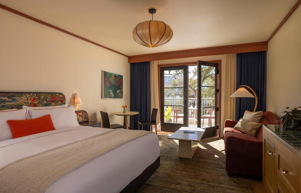 una camera d'albergo con un letto e un soggiorno di Hotel Daphne a Houston