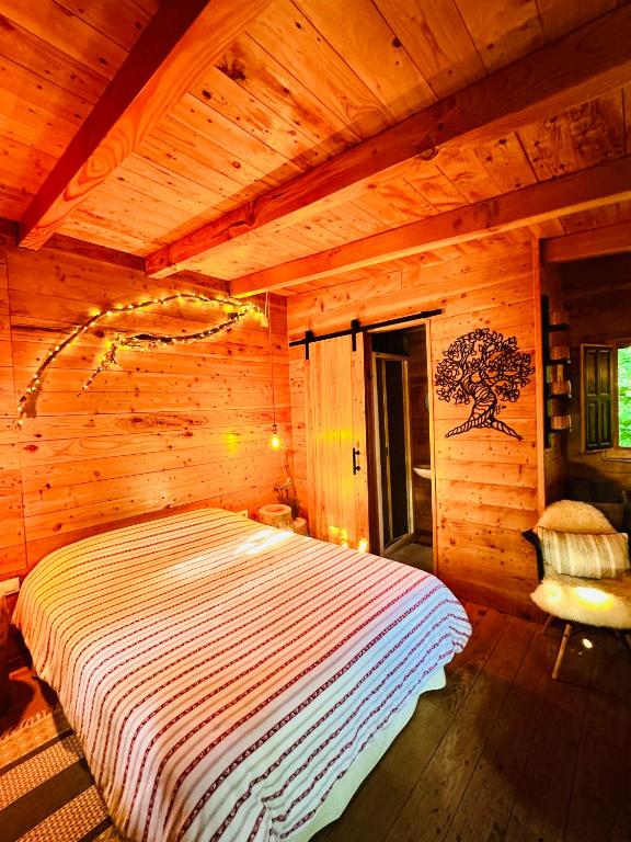 a bedroom with a bed in a wooden room at Nature Tree House Casa sobre los árboles in Tordera