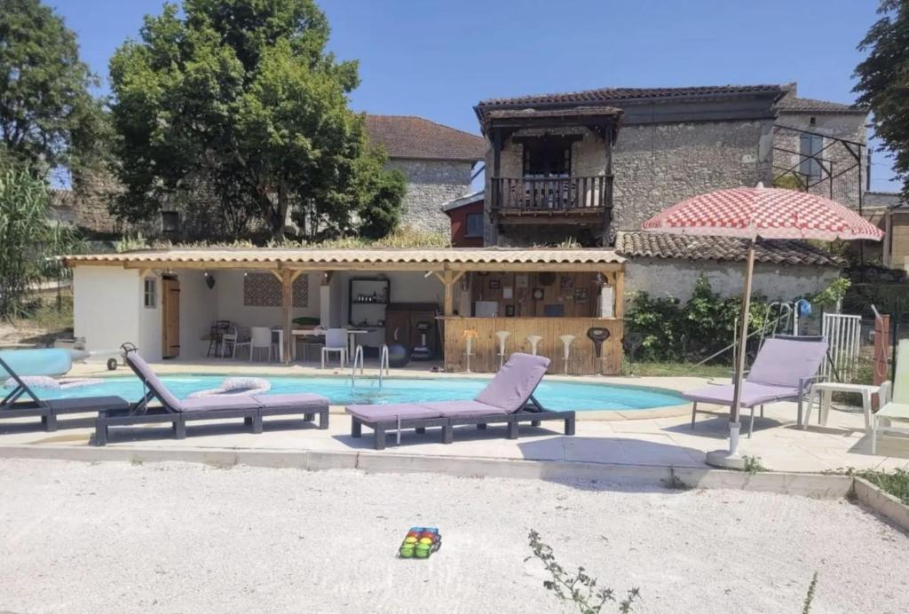 ein Pool mit Stühlen und einem Sonnenschirm und ein Haus in der Unterkunft Le Cottage du Lavoir-La P'tite Maiz in Bourg-de-Visa
