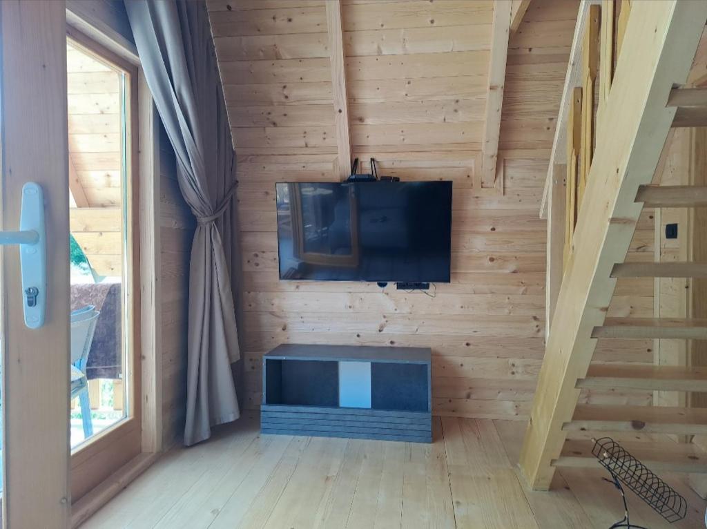 Habitación con TV en la pared y escalera. en Grahovo Čelin Stream, en Grahovo