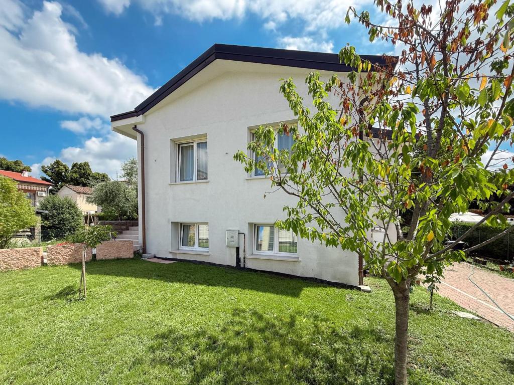 ein weißes Haus mit einem Baum im Hof in der Unterkunft Villa Butterfly in Battaglia Terme