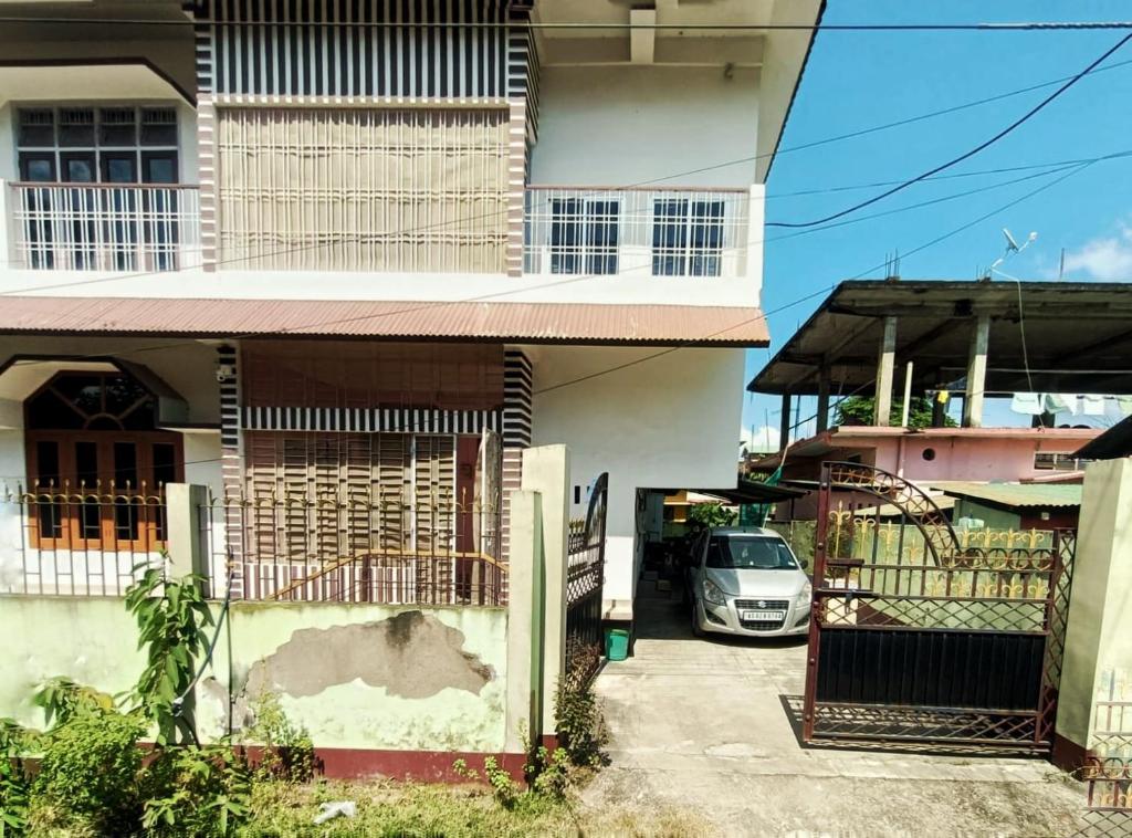 a white car parked in front of a house at Jonaki Abax Homestay in Nowgong