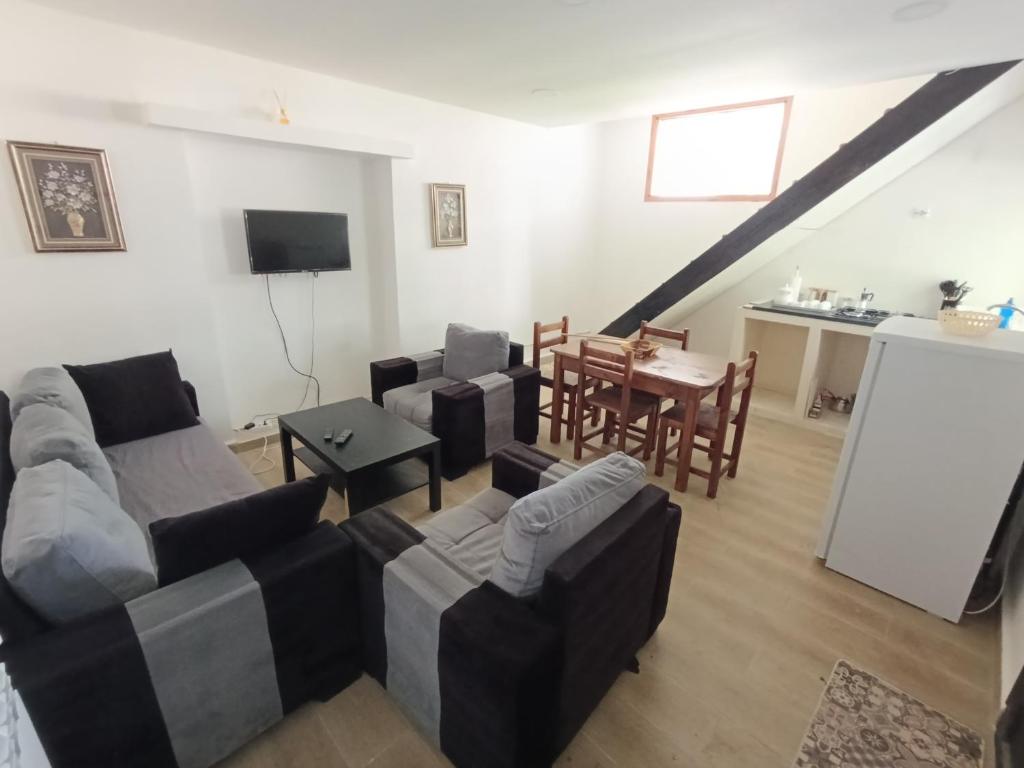 un salon avec des canapés et une table ainsi qu'une cuisine dans l'établissement T3 duplex Annaba Kouba Baie des Corailleurs, à Annaba