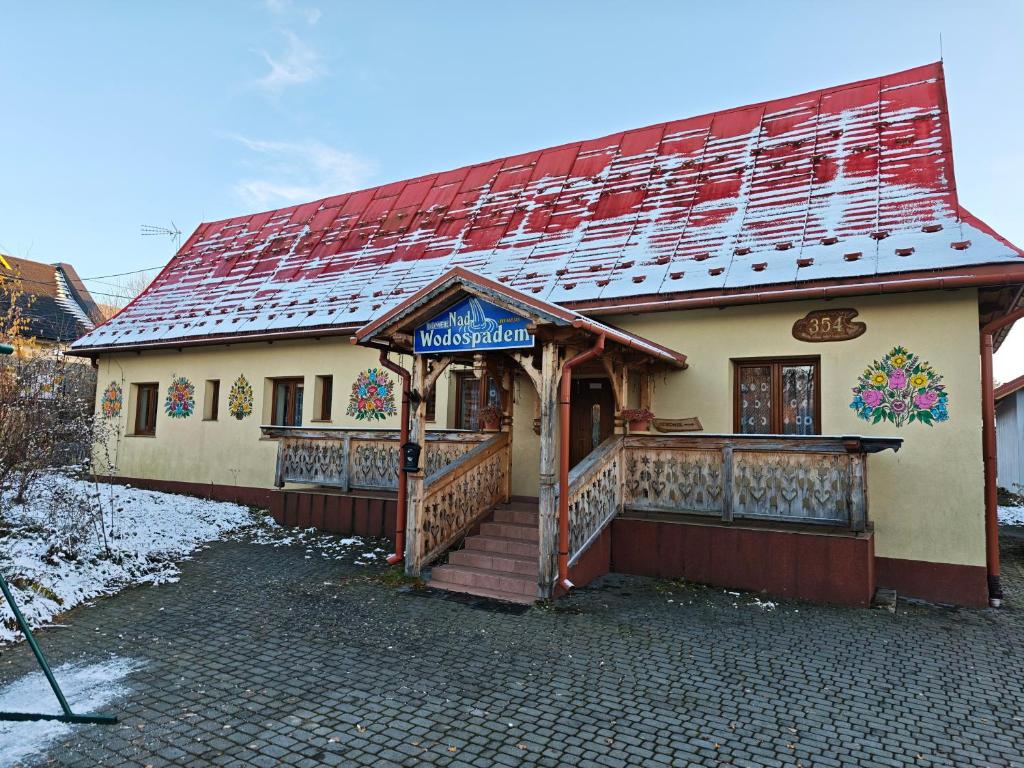 ein Gebäude mit einem Schild an der Vorderseite in der Unterkunft Domek nad wodospadem in Zakopane