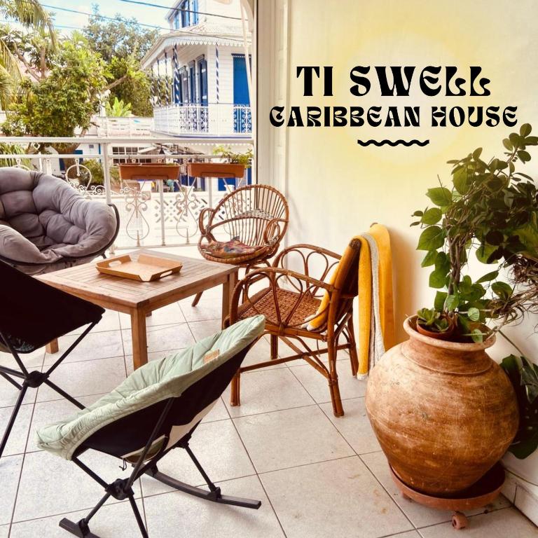 a patio with a table and chairs and a plant at Ti Swell Caribbean House in Port-Louis