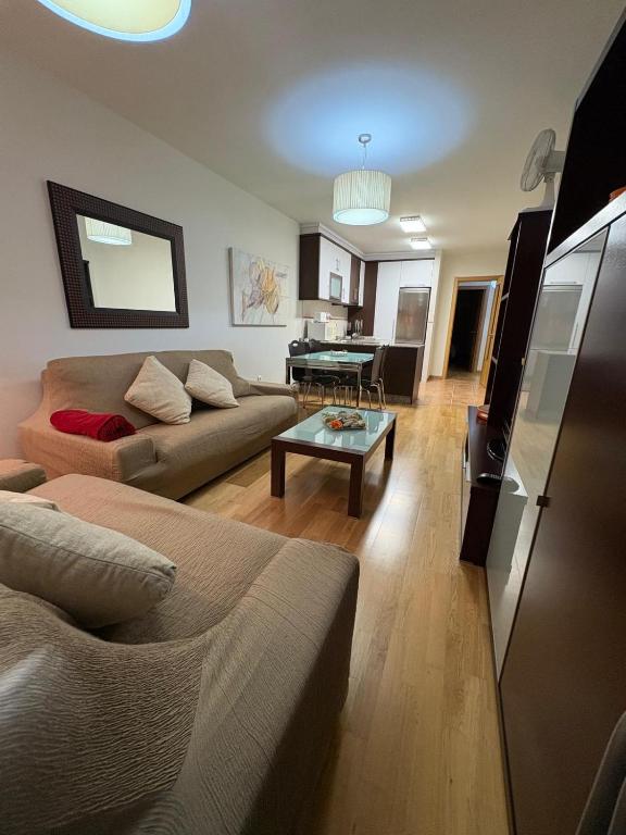 a living room with a couch and a table at Portosín beach apartment in Goyanes
