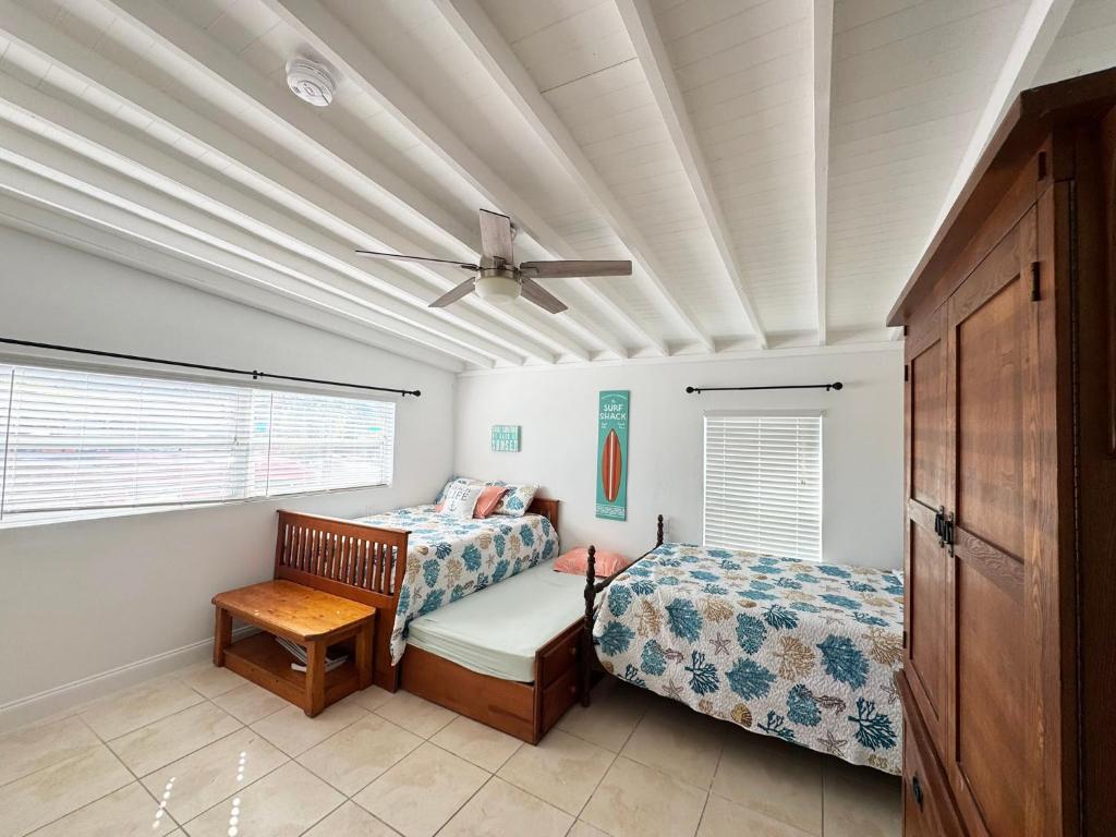 a bedroom with two beds and a ceiling fan at Waterfront Boat Lift Bungalow in St Pete Beach