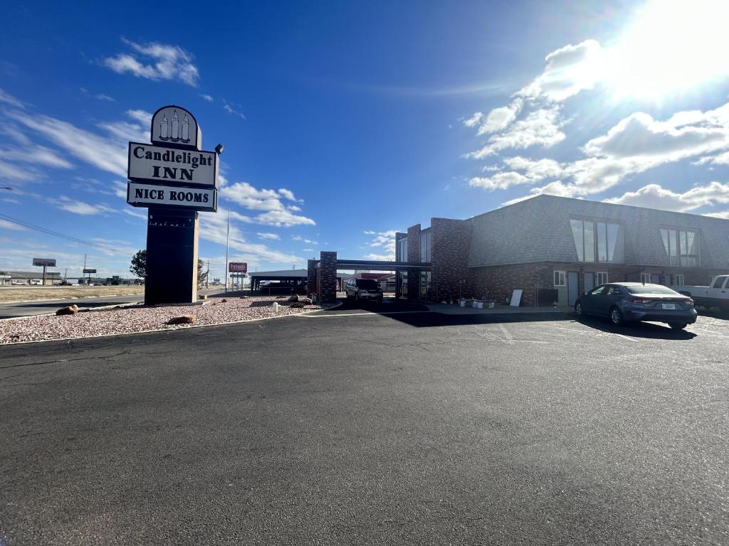 a sign in front of a building with a parking lot at Candlelight Inn by Capital O Scottsbluff in Scottsbluff