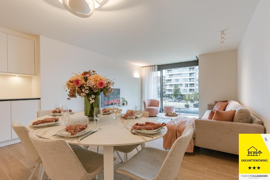 a kitchen and living room with a table and chairs at La Mirage 02 in De Panne