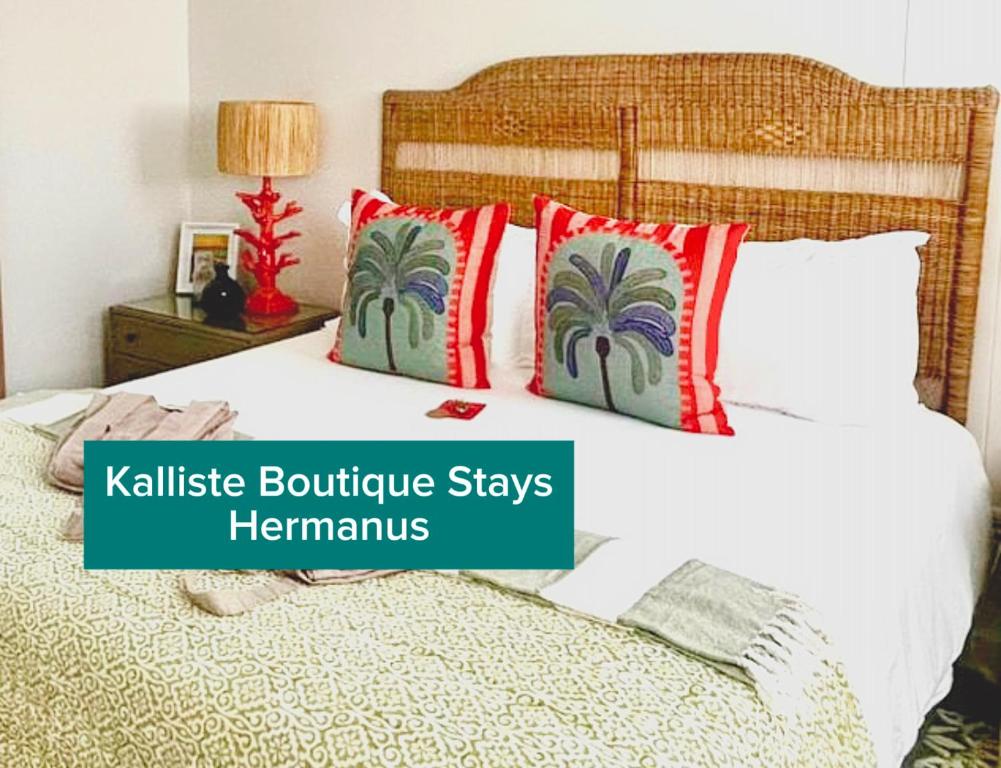 - une chambre avec un lit doté d'oreillers rouges et verts dans l'établissement Kalliste Boutique Stays - Hermanus, à Hermanus