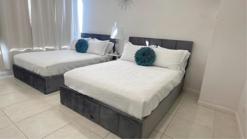 2 camas con almohadas azules en un dormitorio en New Ocean View Condominium, en Honolulu