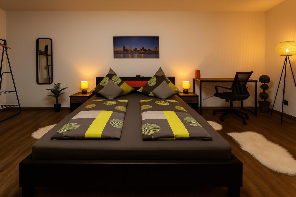 een slaapkamer met een groot bed met gele en grijze kussens bij Homefeld Suite - Elegante und moderne Ferienwohnung zentral in Hünfeld bei Fulda mit Küche, kostenlosem Parkplatz und WLAN in Hünfeld