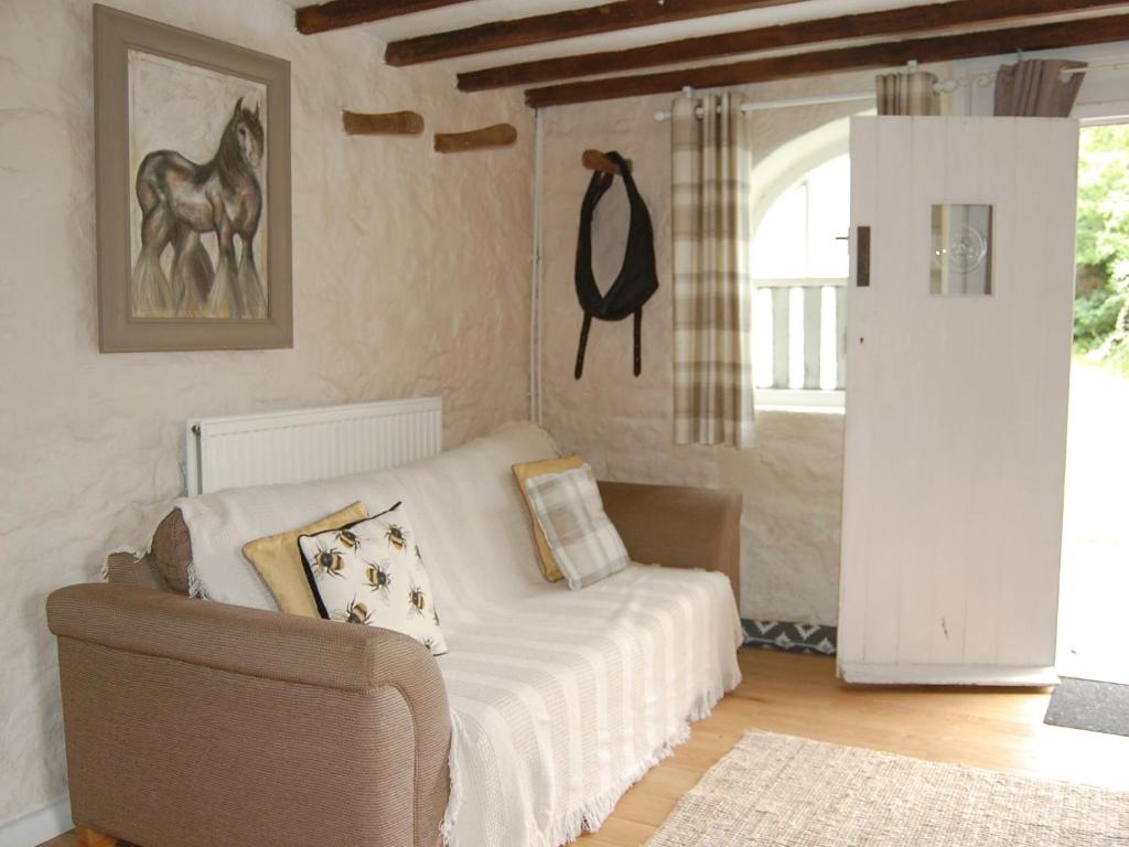 una stanza con un letto, una sedia e una finestra di Shire Cottage a Highpeak Junction