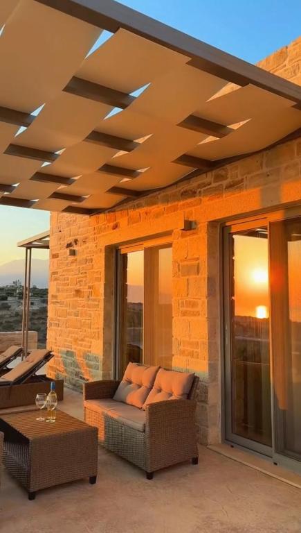 a living room with a couch on a patio at Villa Sofita Komos View in Pitsidia