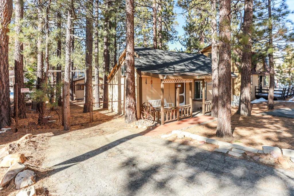 a cabin in the woods with a porch and trees at Pines 23 #1438 in Big Bear Lake