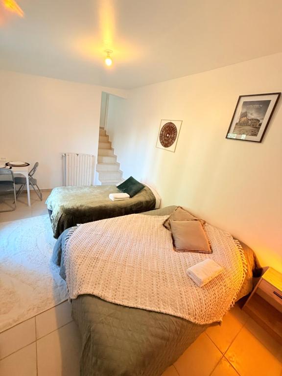 ein Zimmer mit zwei Betten und einer Treppe darin in der Unterkunft Maison Bon Séjour in Livry-Gargan