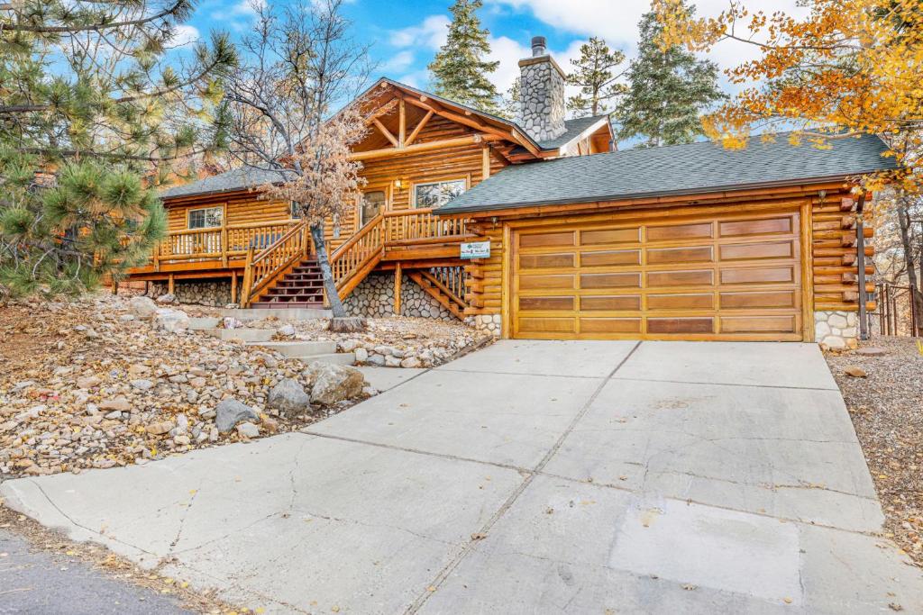 ein Blockhaus mit einer Garage und einem Haus in der Unterkunft Crescenta pines log cabin #2346 in Big Bear Lake