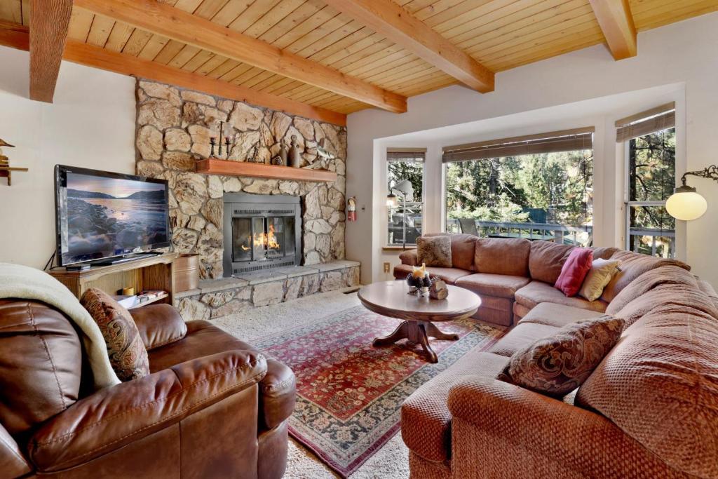ein Wohnzimmer mit Ledermöbeln und einem Steinkamin in der Unterkunft Tree top views #2060 in Big Bear Lake