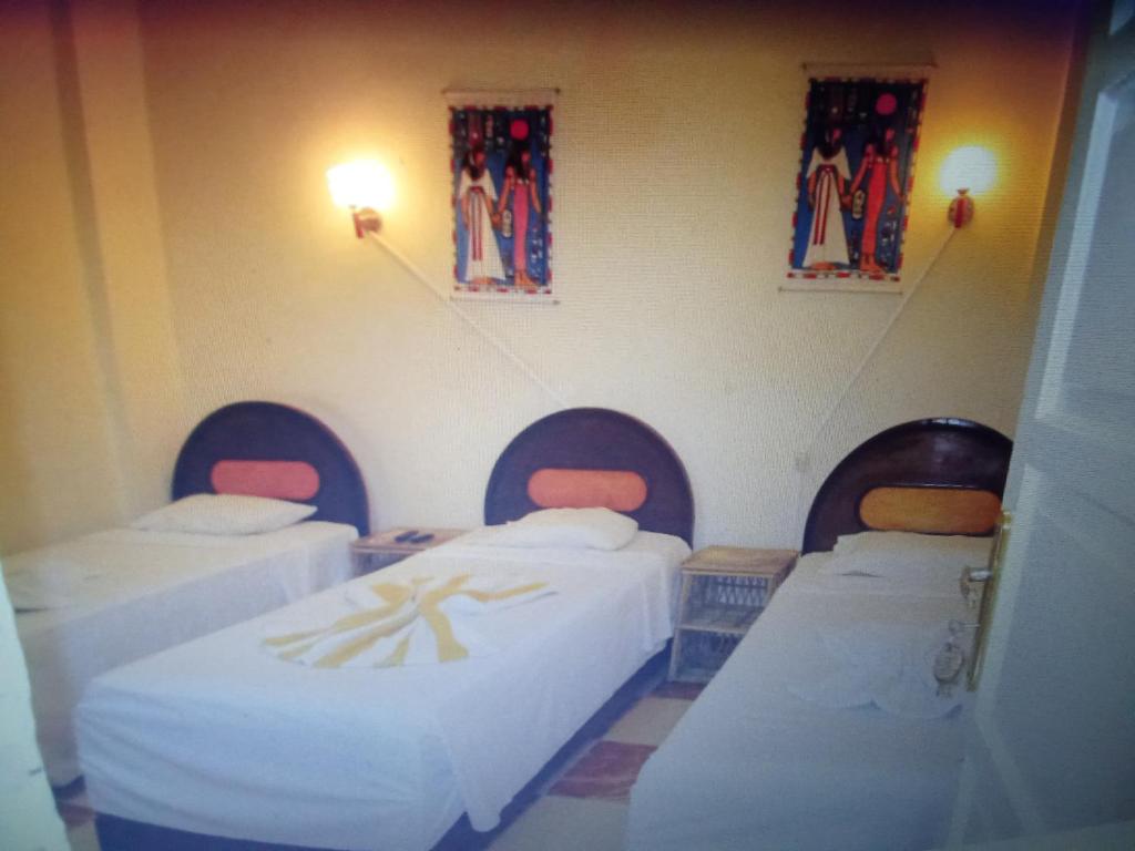 a room with three beds in a room at King Square B&B Hostel luxor in Luxor