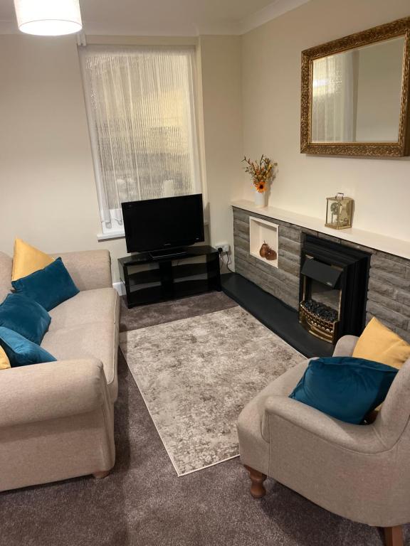a living room with two couches and a fireplace at King Edward house in Rhymney