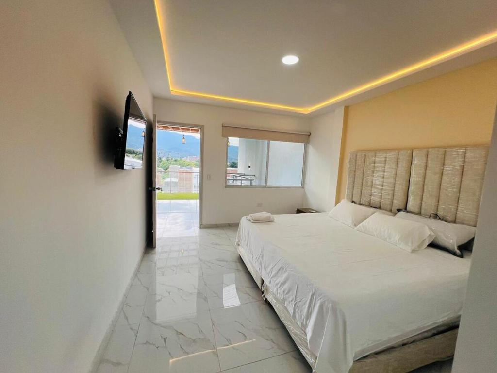 a bedroom with a bed and a television in it at Penthouse Duplex Apartment en Cali, Ciudad 2000 in Cali