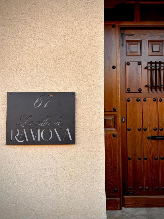 a sign on the side of a building next to a door at La villa de Ramona in Argamasilla de Alba