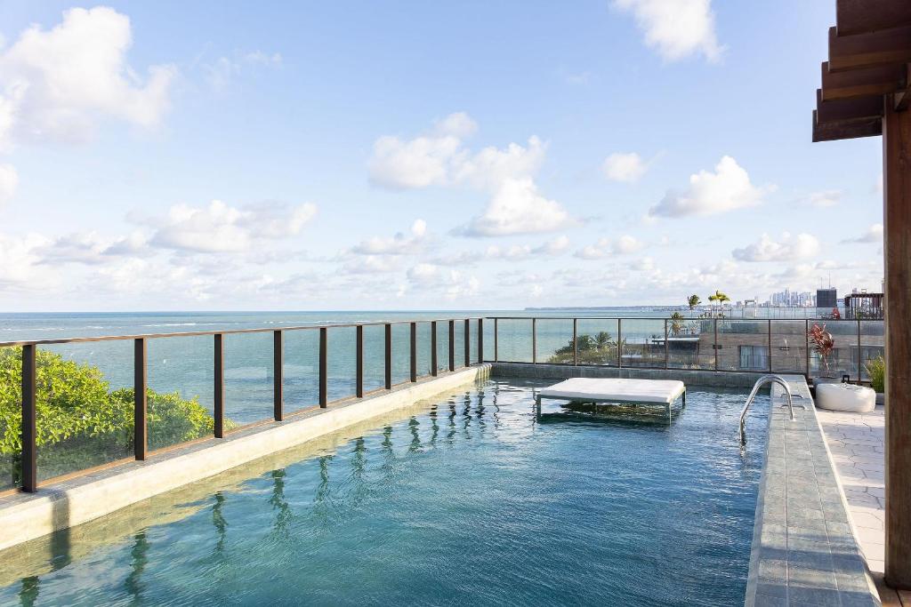 a swimming pool with a view of the ocean at Get Sense #306 - Beira mar por Carpediem in Tambaú