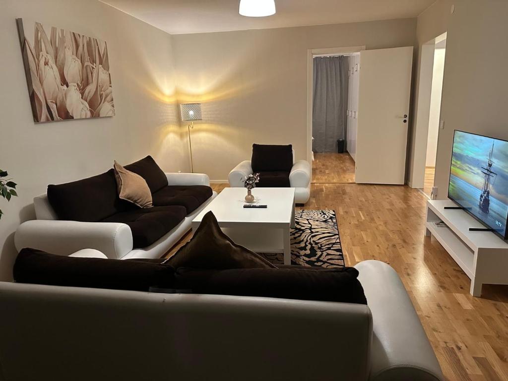 un salon avec deux canapés et une télévision à écran plat dans l'établissement Noah longstay Kungsfågelgatan, à Västerås