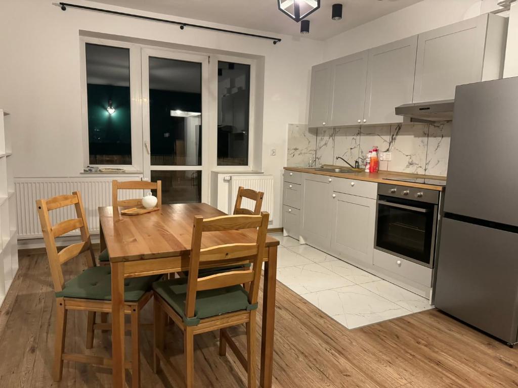 a kitchen with a table and chairs and a refrigerator at Apartament Siedlce ul Szkolna 4 in Siedlce