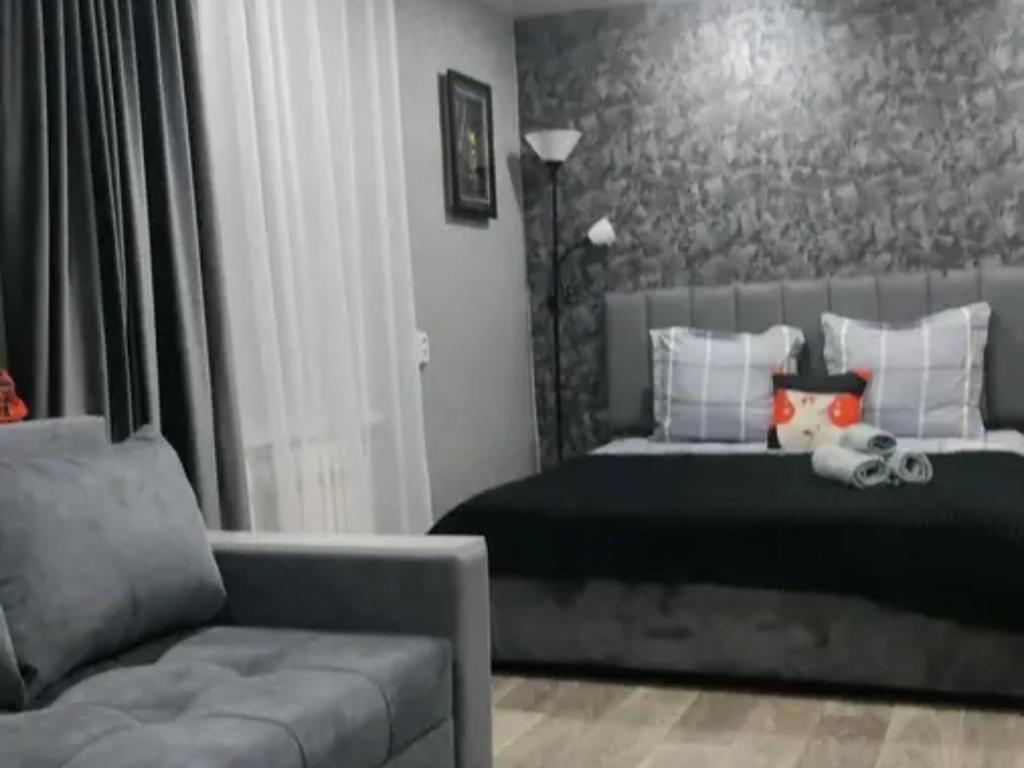 une chambre avec un lit et un canapé dans l'établissement квартира Центр, à Semey