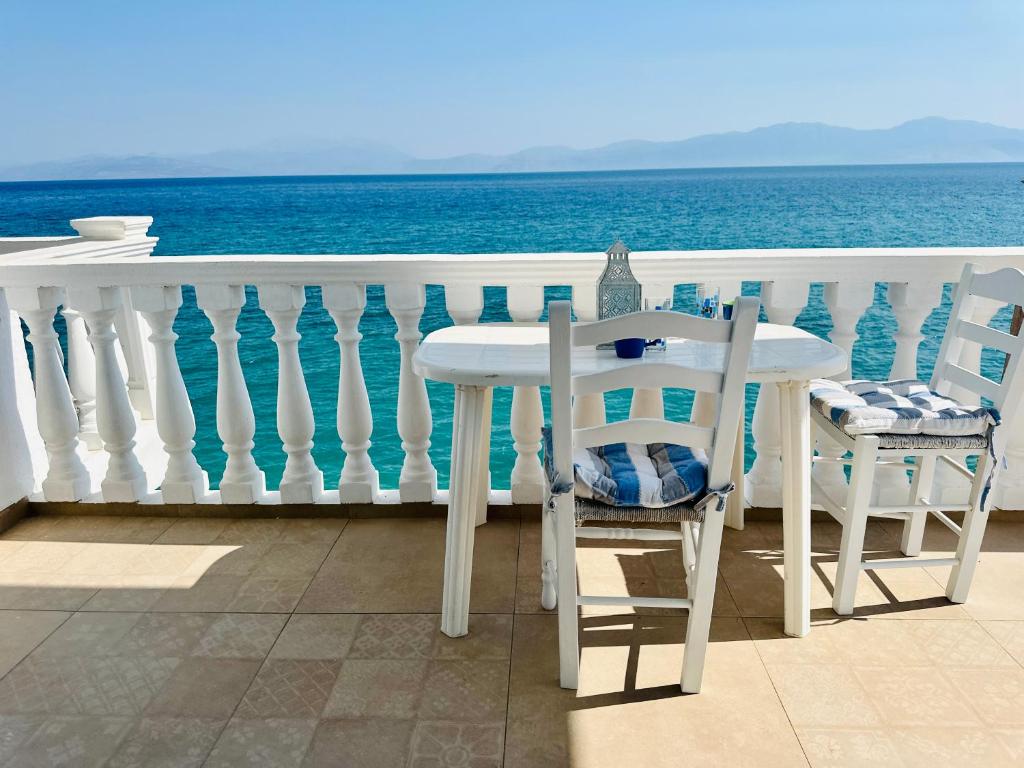 a table and chairs on a balcony with the ocean at Agapi in Xylokastro