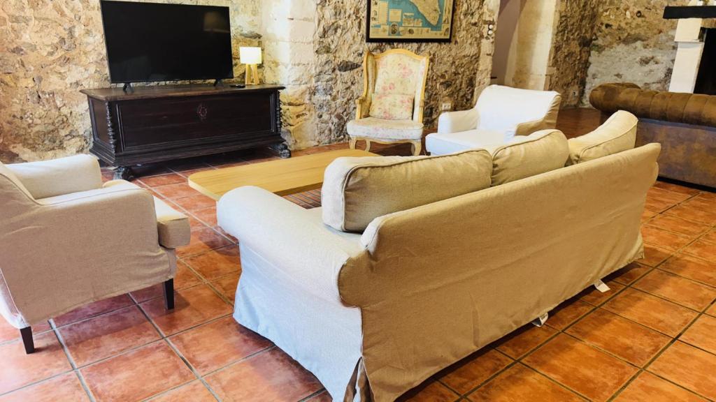 ein Wohnzimmer mit einem Sofa, 2 Stühlen und einem TV in der Unterkunft Holiday Home Finca Binimazoch in Port d'Addaia