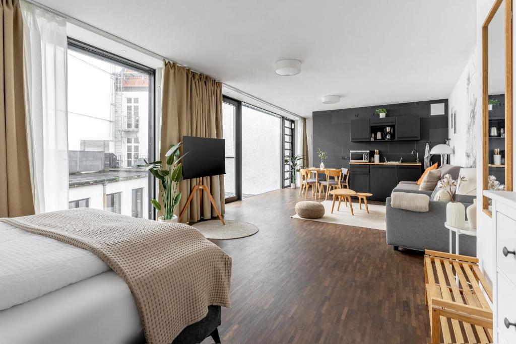 a bedroom with a bed and a living room at Global Living - Design Apartment I Rathausplatz I Kitchen I Augsburg in Augsburg