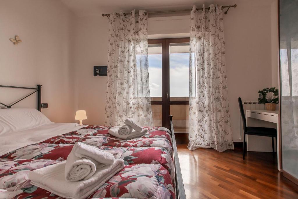 a bedroom with a bed and a desk and a window at Alloggio turistico Leonardo Home- Fiumicino Airport, 2m in treno- Rome, 20m in treno- Fiera, 2m in treno in Fiumicino