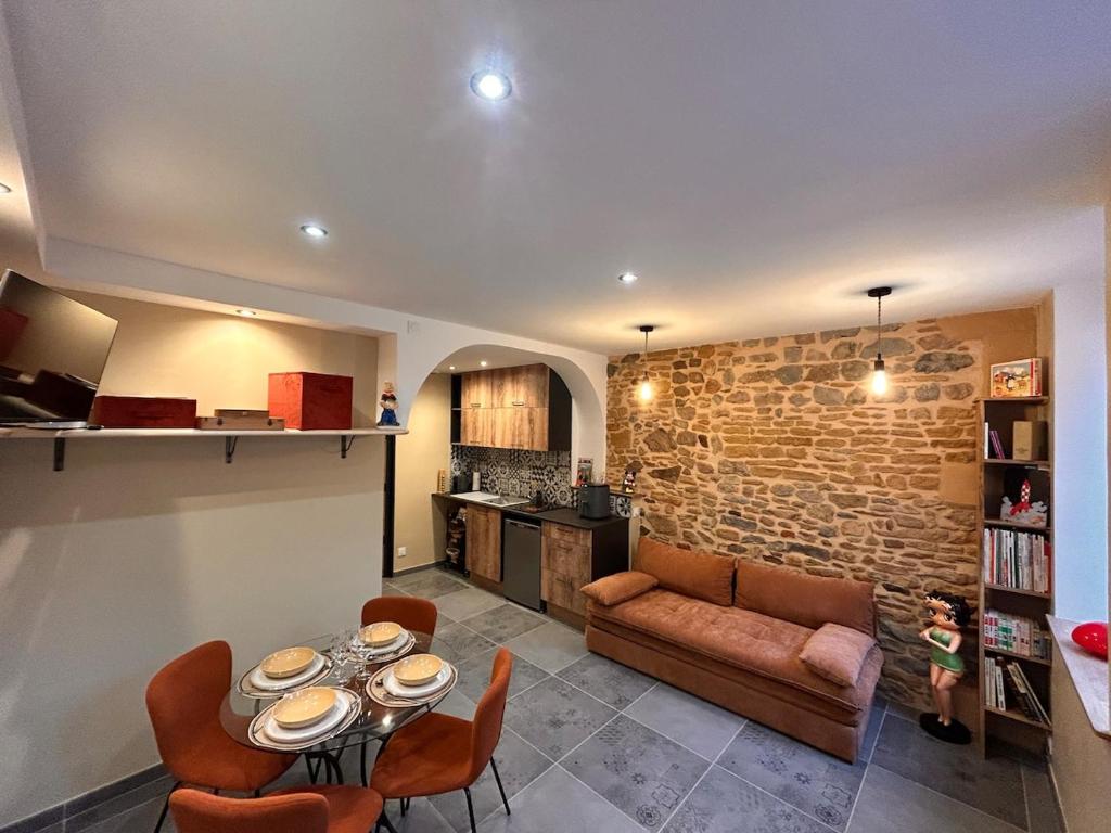 eine Küche und ein Wohnzimmer mit Tisch und Stühlen in der Unterkunft BullyCosy in Bully