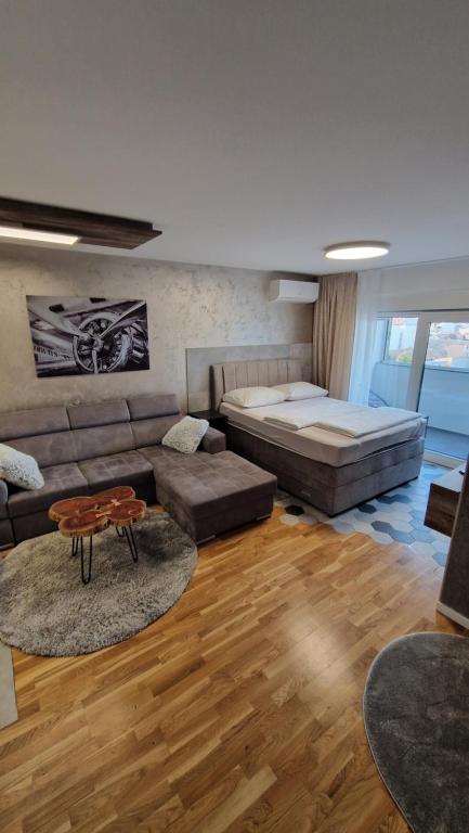 ein Wohnzimmer mit einer Couch und einem Bett in der Unterkunft Premium sunrise in Osijek