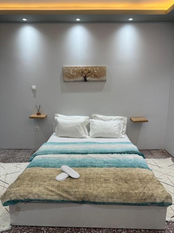 a bed with two white slippers on top of it at Cozy Central Home with Balcony in Alexandroupoli
