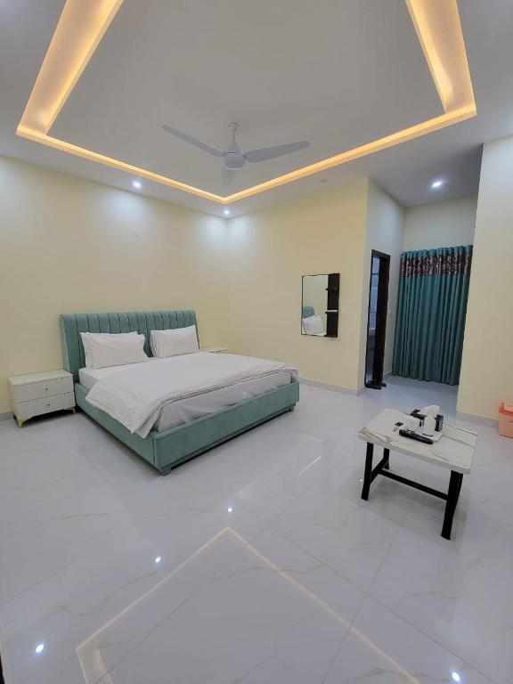 a bedroom with a bed and a table in it at Airport Gateway Guesthouse in Rawalpindi
