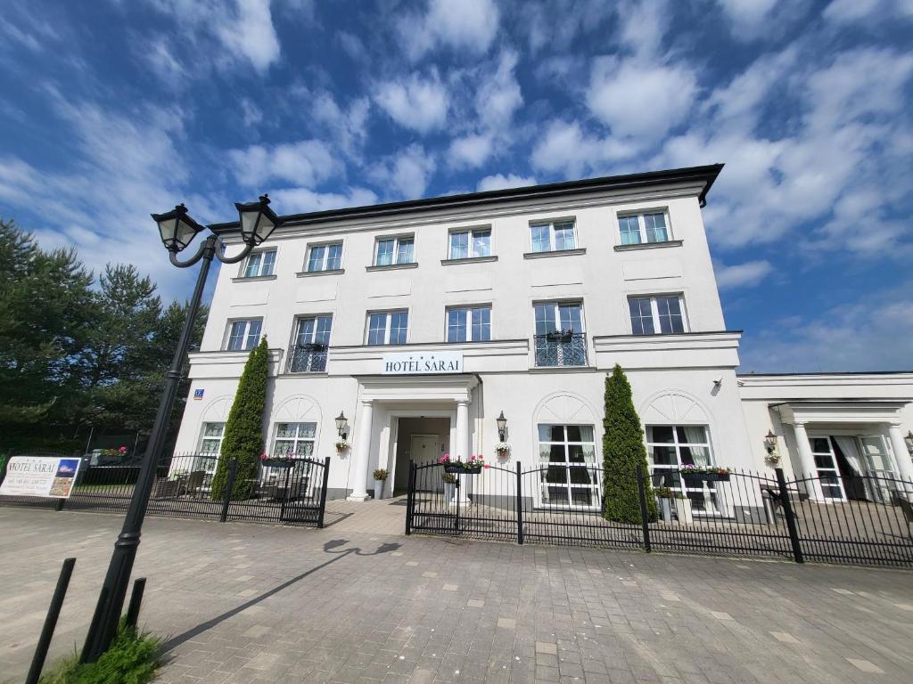 a white building with a street light in front of it at Hotel Sarai Wrocław in Wrocław