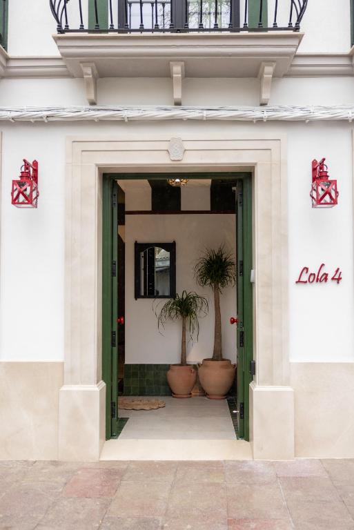 a doorway to a building with two potted plants at Estudio Lola4 in Lucena