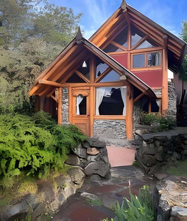 a small house with a pond in front of it at Los Retoños in El Bolsón